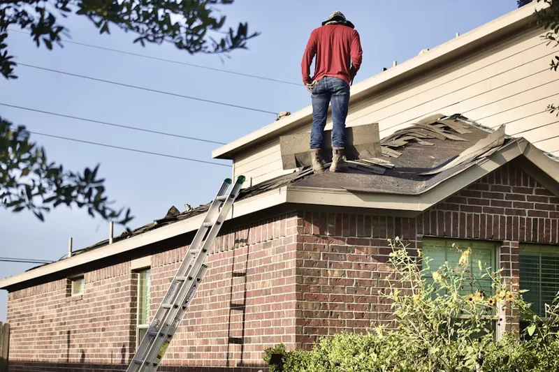 Professional roofer working on a residential roof in Penderwood